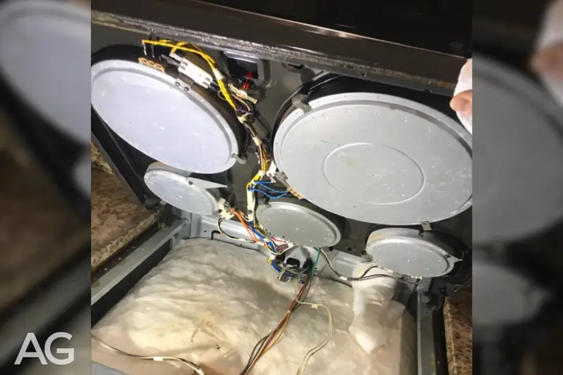 Heating and electrical components visible beneath a range cooktop