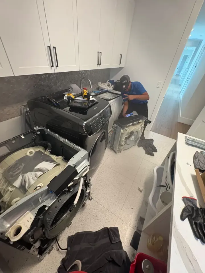 Technician beside a Samsung FlexWash with the upper washer assembly removed during a lid-replacement service visit
